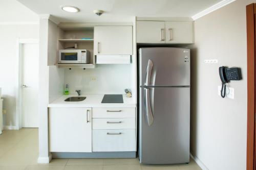 una cucina con frigorifero e armadietti bianchi di Suite 1107 Hermosa vista al rió Guayas con Jacuzzi a Guayaquil