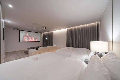 a hotel room with two beds and a flat screen tv at Aank Hotel Daejeon Yuseong 2nd in Daejeon