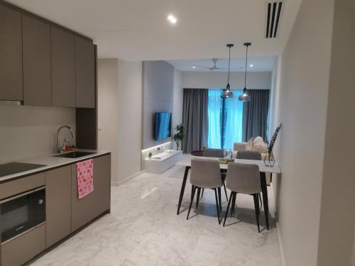 a kitchen and living room with a table and chairs at EATON RESIDENCE AT KLCC in Kuala Lumpur