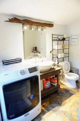 a bathroom with a tv on a counter with a toilet at Cozy Home with Big Yard - Full Kitchen-More Than a Hotel Stay! in Lyles
