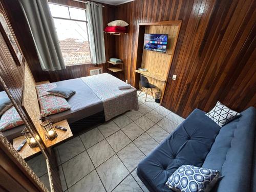 イタジャイにある8 Quarto Cama Queen e SmartTv Netflixのベッド、ソファ、テレビが備わる客室です。
