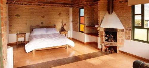 a bedroom with a bed and a fireplace at Encanto - Habitación con baño privado in Villa de Leyva