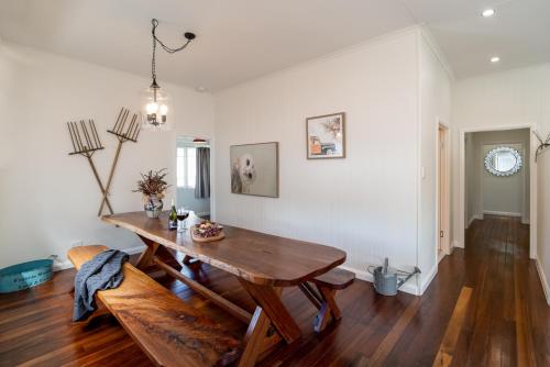 a dining room with a wooden table and chairs at Bank House Tamborine Mountain in Mount Tamborine
