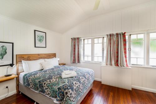 a bedroom with a bed and two windows at Bank House Tamborine Mountain in Mount Tamborine