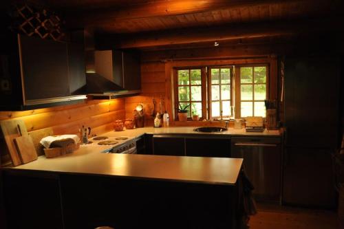 a kitchen with a stove and a counter top at Bjælkehuset på Harrild Hede in Brande