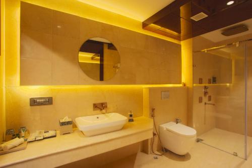 a bathroom with a sink and a toilet and a shower at Sunhill Portico in Siliguri