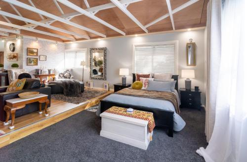 a bedroom with a bed and a living room at The Chefs Cottage in Waikanae