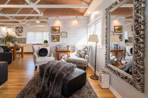 a living room with a mirror and a couch at The Chefs Cottage in Waikanae