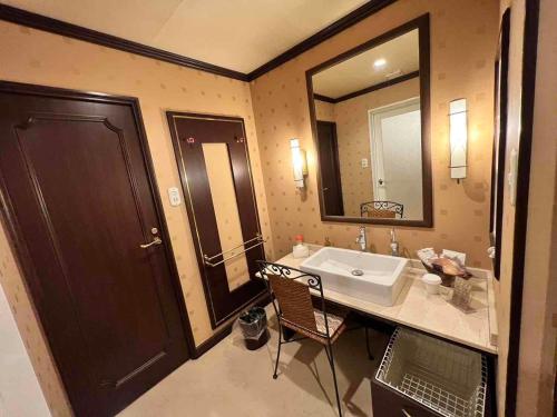 a bathroom with a sink and a large mirror at HOTEL ULURU in Kobe