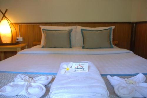 1 dormitorio con 1 cama con toallas en Montalay Beach Resort en Ko Tao