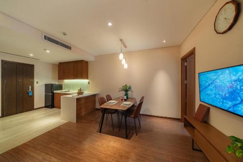 a kitchen and dining room with a table and a tv at DHTS Business Hotel & Apartment in Ho Chi Minh City