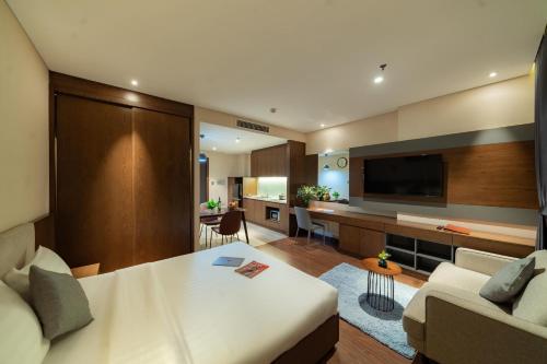 a bedroom with a large bed and a living room at DHTS Business Hotel & Apartment in Ho Chi Minh City