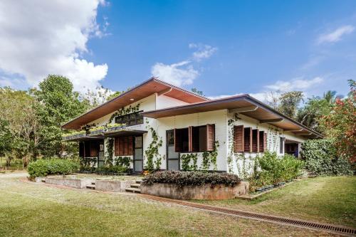 a white house with red shutters and a yard at Pintoresco in Anuling