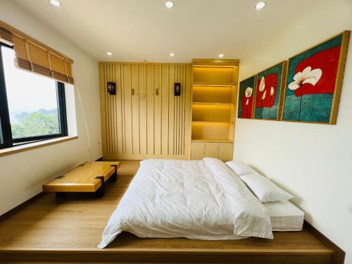 ein Schlafzimmer mit einem Bett und einer Bank darin in der Unterkunft Trippy villa: FLC Hạ Long in Hạ Long