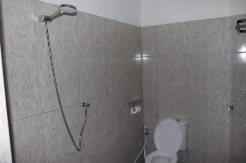 a bathroom with a shower with a toilet in it at Room 212 in Kuta Lombok