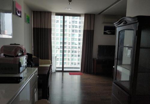 a living room with a kitchen and a large window at Sathon Luxury High-rise Apartment City View KingPower ,IconSiam ,BNH,Silom in Bangkok