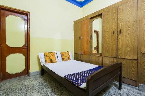 ein kleines Bett in einem Zimmer mit Holzschränken in der Unterkunft SPOT ON Cherish Guest House in Ranchi