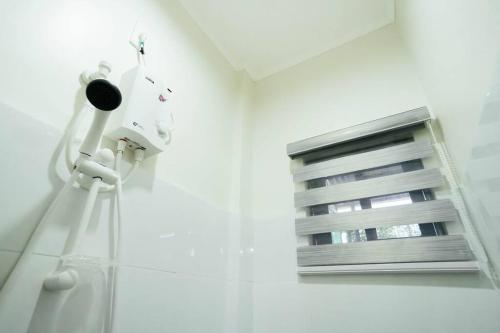 a bathroom with a window and a blow dryer at Cozy BNB - Unit L in Batangas City