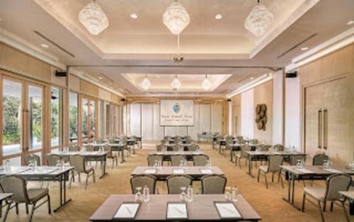 a banquet hall with tables and chairs and windows at Sea Sand Sun Resort and Villas - SHA Plus in Na Jomtien