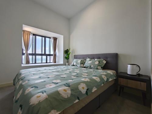 a bedroom with a bed with a green comforter and a window at Trevor bathtub Imperio residence seaview jonker5min in Melaka