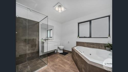 a bathroom with a tub and a toilet and a sink at Tranquil Retreat 10 Min to Hobart-WIFI Smart TV in Hobart