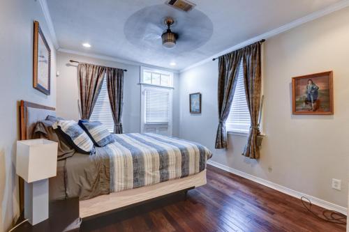 a bedroom with a bed and two windows at Step into the French Quarter in New Orleans