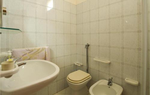 a white bathroom with a toilet and a sink at Beautiful Home In Marinella Di Selinunte With Kitchenette in Marinella di Selinunte