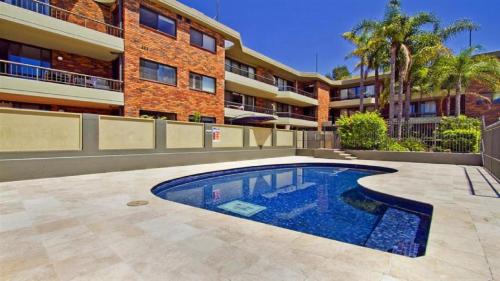 a swimming pool in front of a building at Terrigal Bay #9 Pool In Complex, Close To Beach Accom Holidays in Terrigal