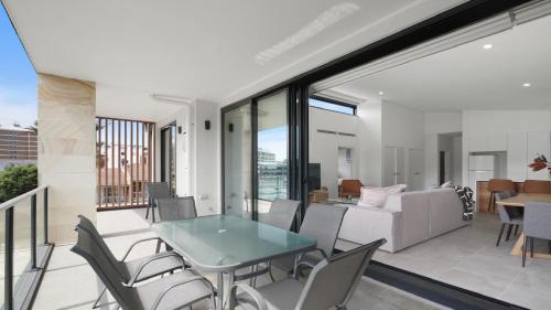 a living room with a glass table and chairs at #8 The Ash Apartments Close To Beach Accom Holidays in Terrigal