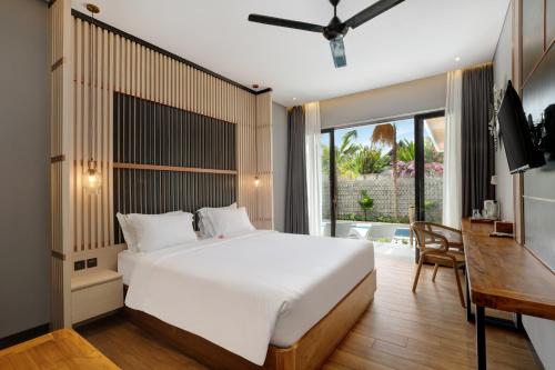 a bedroom with a large white bed and a desk at Amandaya Canggu in Canggu