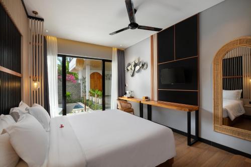 a bedroom with a white bed and a mirror at Amandaya Canggu in Canggu