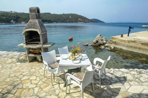 a table and chairs with a oven in the water at Apartment More 1 - sea front in Savar