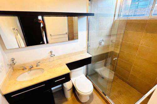 uma casa de banho com um WC, um lavatório e um chuveiro em Departamento 3 dormitorios 2 baños, 2 TV, Piso Alto, República de El Salvador em Quito