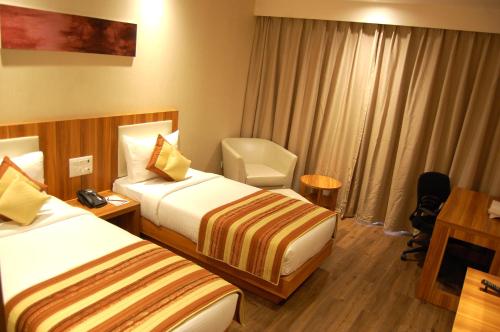 a hotel room with two beds and a desk at Hotel Le Roi Raipur at Raipur Railway Station in Raipur