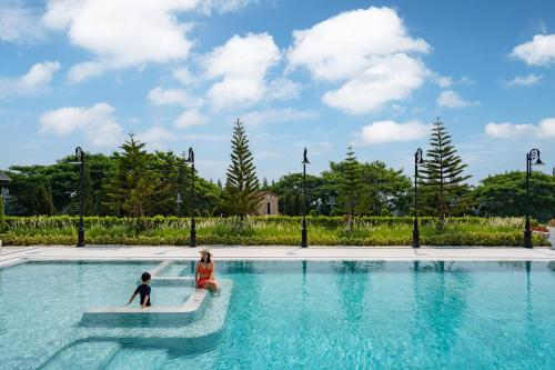 a woman and a child in a swimming pool at Estella Khao Yai in Khao Yai