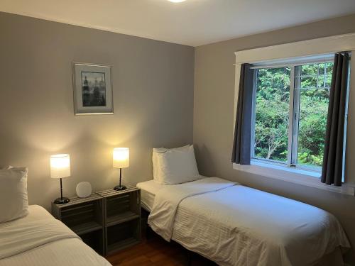 - 2 lits dans une chambre avec 2 lampes et une fenêtre dans l'établissement Sienna's Tree House (Tall Trees And Salty Breeze), à Tofino