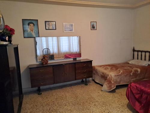a bedroom with a bed and a dresser and a mirror at Casa Martha in Ciudad Nezahualcóyotl