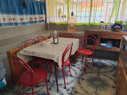 uma mesa com cadeiras vermelhas e uma mesa e uma mesa e uma mesa e cadeiras em Casa Martha em Ciudad Nezahualcóyotl