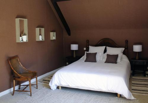 a bedroom with a large white bed and a chair at Villa les Isards au cœur d'Argelès-Gazost in Argelès-Gazost