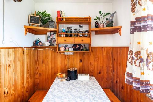 a room with wooden walls and a table and shelves at Book house 