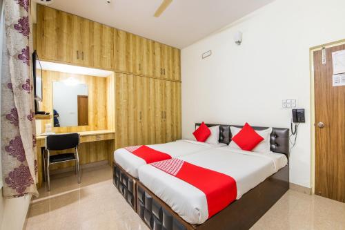 a bedroom with a large bed with red pillows at OYO Flagship 69694 Sagar Comforts in Yelahanka