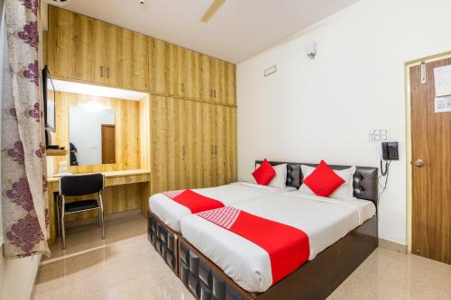a bedroom with a large bed with red pillows at Hotel O Sagar Comforts in Bengaluru
