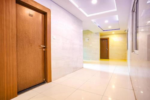 an empty hallway with a door and a tile floor at FabHotel Uday Vilas in Indore