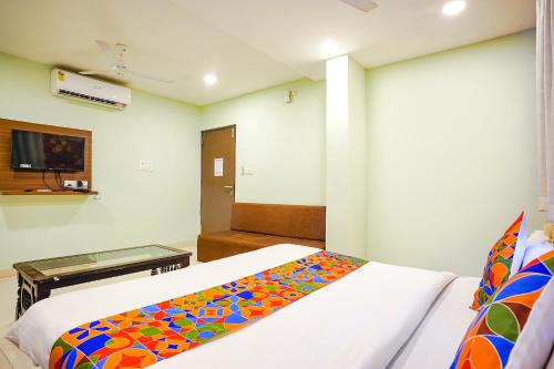 a bedroom with two beds with a colorful blanket at FabHotel Uday Vilas in Indore
