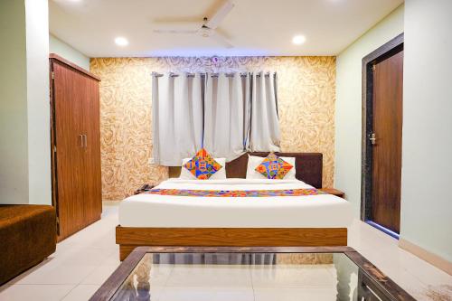 een slaapkamer met een bed en een raam bij FabHotel Uday Vilas in Indore