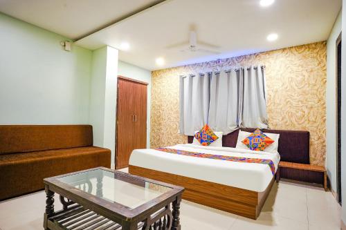 een slaapkamer met een bed en een salontafel bij FabHotel Uday Vilas in Indore