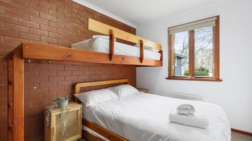 a bedroom with a bunk bed with white sheets at Brockhoff Lachen in Mount Hotham
