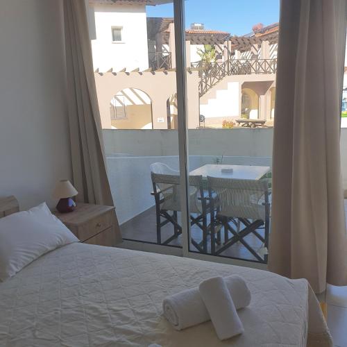 a bedroom with a bed and a balcony with a table at EMILIA 10 STUDIO in Polis Chrysochous