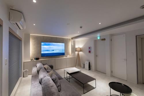 a living room with a couch and a tv at ONE WORLD Sakaisuji Honmachi in Osaka