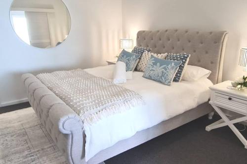 a bedroom with a large white bed with a mirror at Ocean View Villa, 2 bedroom in Mandurah